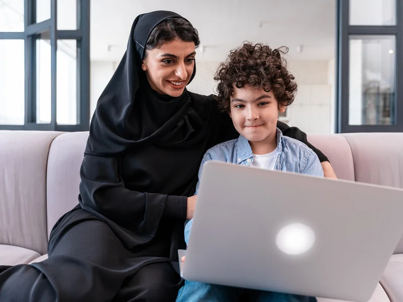 صورة توضيحية لأم وطفل يتعلمان عبر حاسوب محمول في المنزل