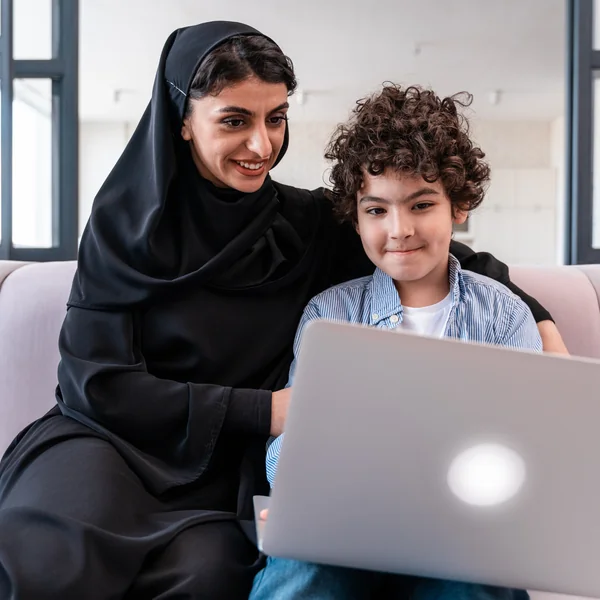 صورة توضيحية لأم وطفل يتعلمان عبر حاسوب محمول في المنزل